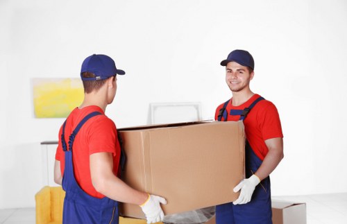 Flat removals in Southnorwood with moving boxes and furniture in an apartment hallway